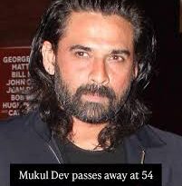 Portrait of Indian actor Mukul Dev smiling, wearing a formal suit, in a dimly lit background.