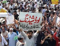 “A crowd of people protesting in Lahore under the scorching sun with signs and police presence, during a severe heatwave and power outage.”