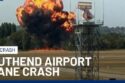 Wreckage of small medical plane crash in flames at London Southend Airport with smoke billowing into the sky, emergency responders on scene.