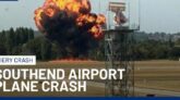 Wreckage of small medical plane crash in flames at London Southend Airport with smoke billowing into the sky, emergency responders on scene.