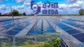 A red downward graph showing IREDA share price fall with renewable energy icons in the background.