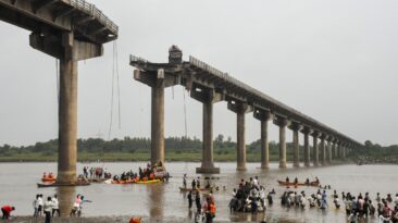 Collapsed portion of the Gambhira Bridge with rescue teams retrieving vehicles from Mahisagar River in Vadodara, Gujarat.