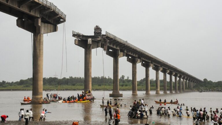 Collapsed portion of the Gambhira Bridge with rescue teams retrieving vehicles from Mahisagar River in Vadodara, Gujarat.